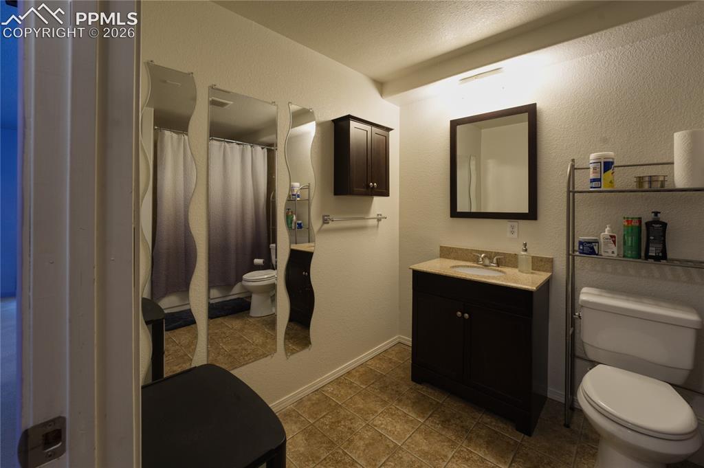 Image 41 of 45: Bathroom featuring a dark wood vanity with a light-toned countertop, a fram