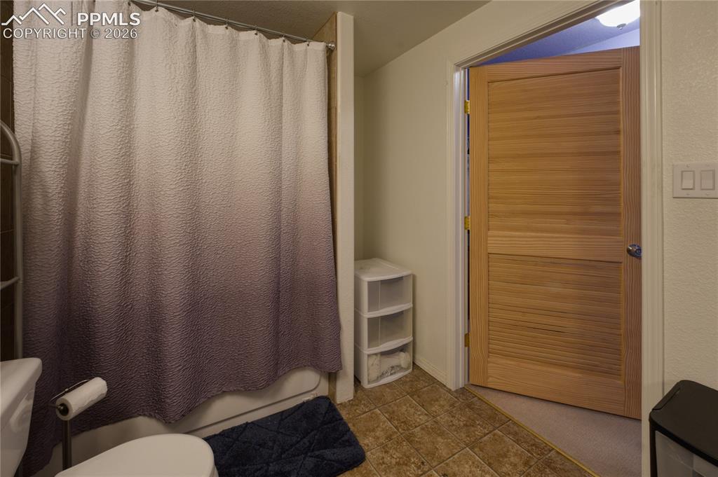 Image 42 of 45: Full bathroom featuring a shower-over-tub combination and tiled flooring