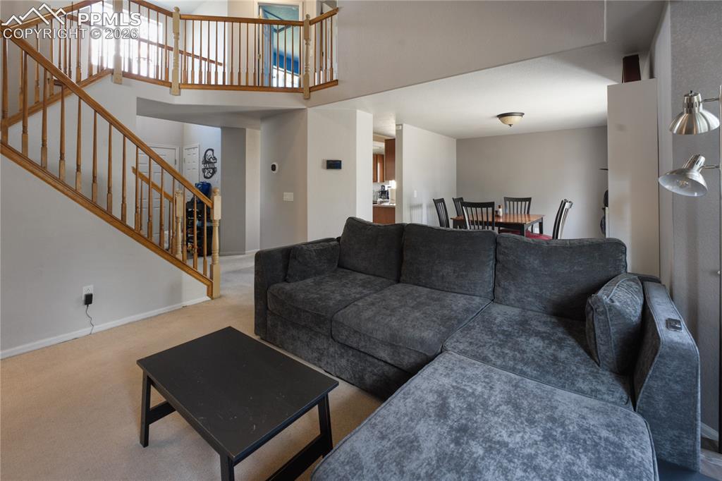 Image 5 of 45: Two-story living area with wood balustrade staircase