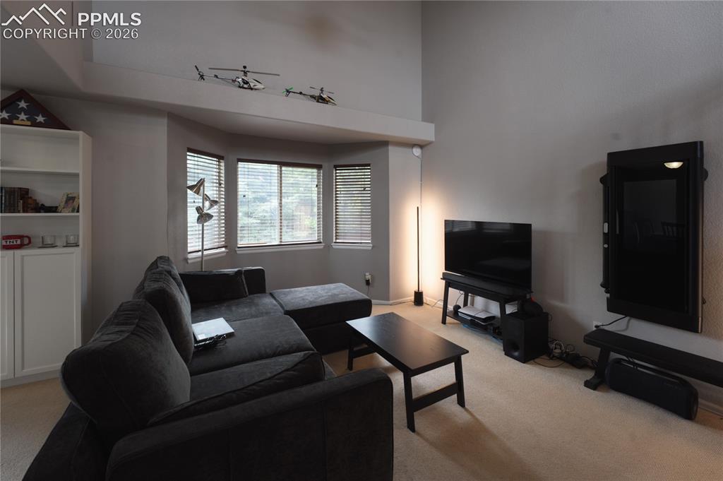 Image 6 of 45: Living area featuring neutral wall tones, a built-in shelving unit with low