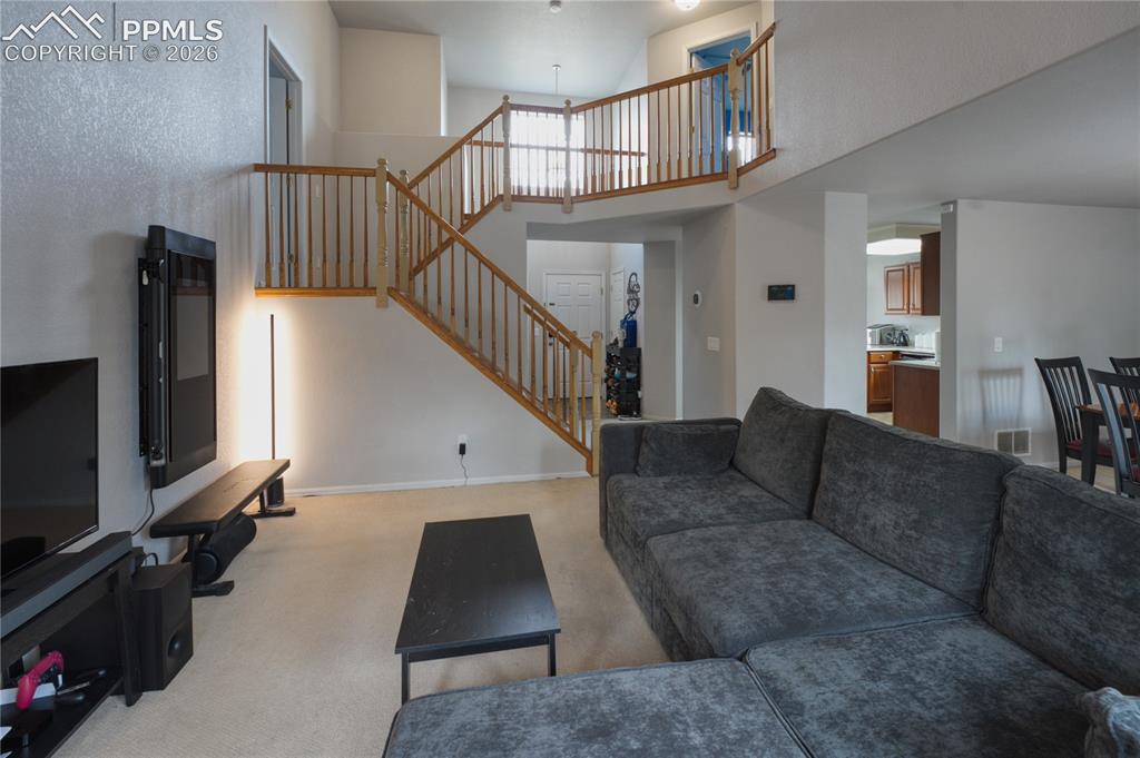 Image 7 of 45: Vaulted ceilings enhance this open-concept living area featuring a prominen