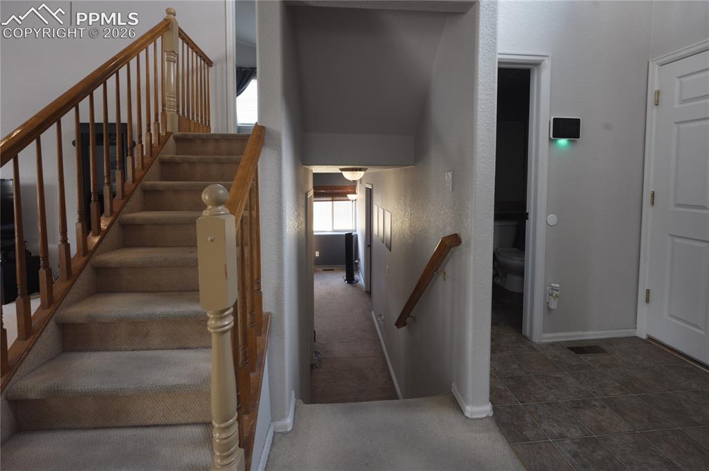 Image 9 of 45: Staircase featuring wood-finish banisters and carpeted treads