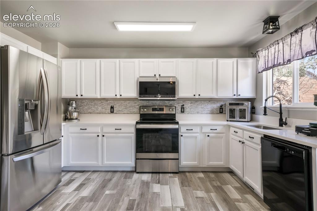 Image 10 of 50: Kitchen with new LVP floors, stainless steel appliances and abundant cabine
