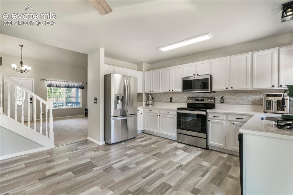 Image 11 of 50: Kitchen with new LVP floors, stainless steel appliances and abundant cabine