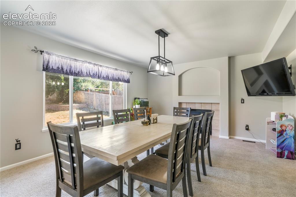 Image 14 of 50: Currently staged as dining area, also family room with gas fireplace