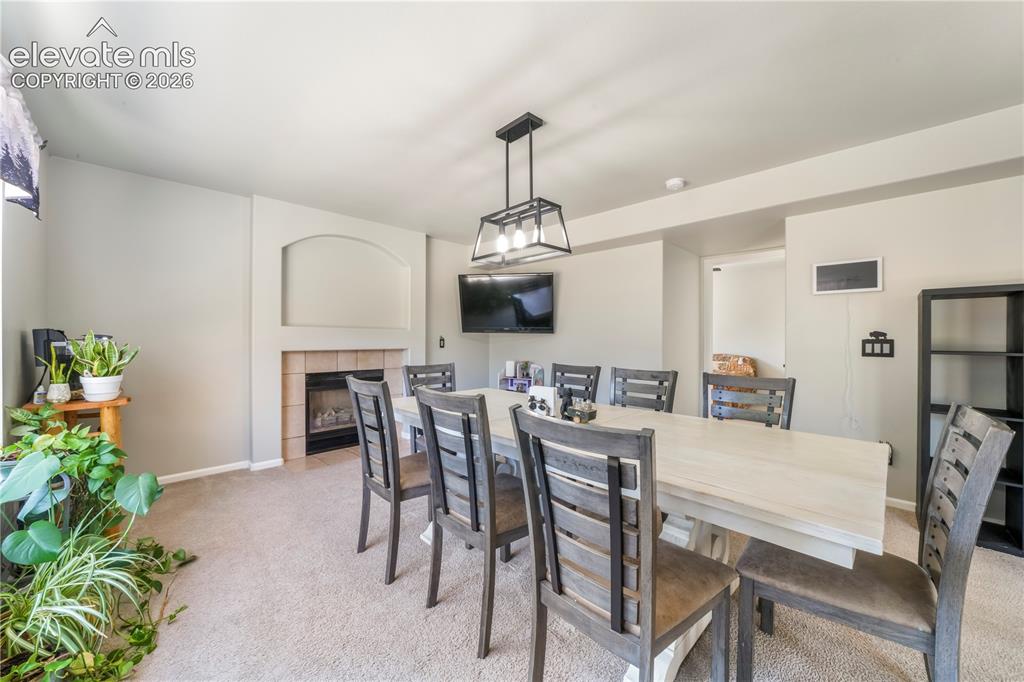 Image 17 of 50: Currently staged as dining area, also family room with gas fireplace