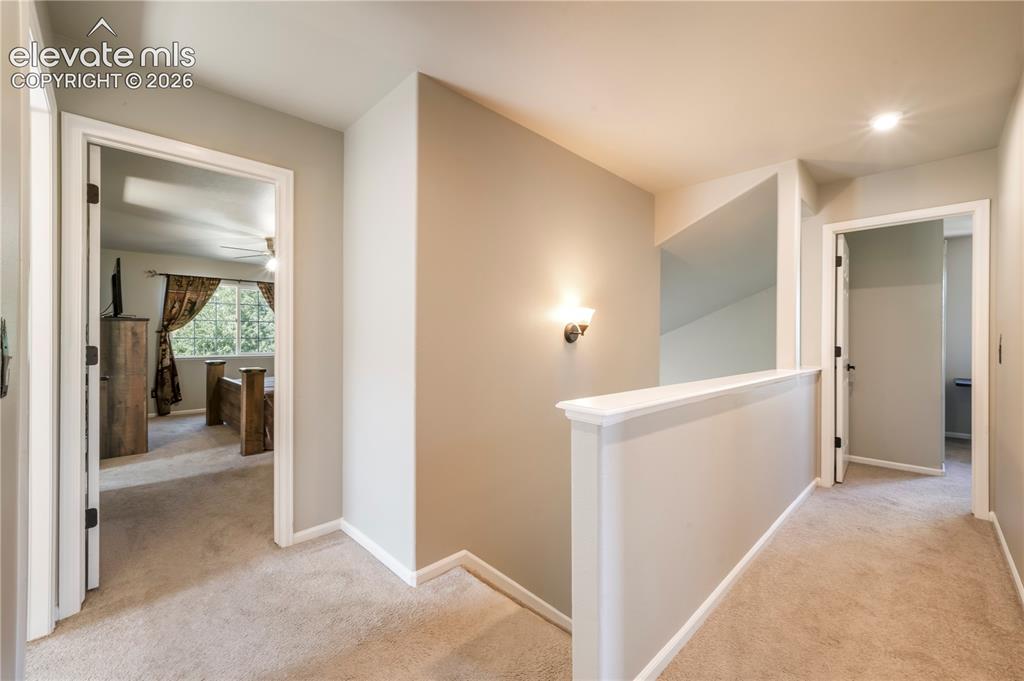 Image 23 of 50: Upstairs view of primary bedroom and additional bedrooms