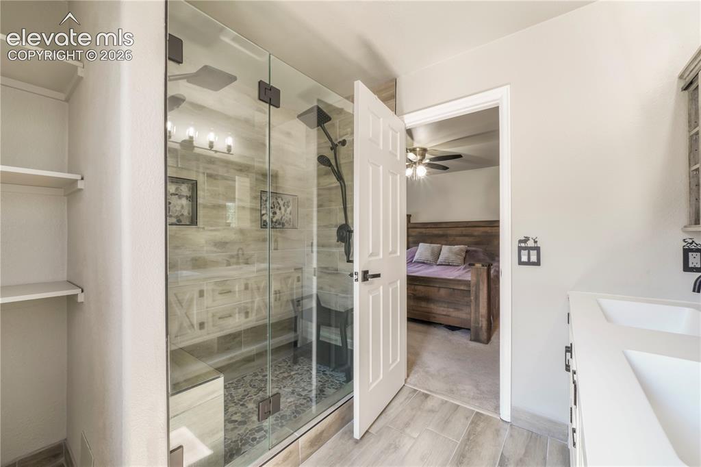 Image 29 of 50: Upstairs primary updated bathroom with large walk in shower and dual vantie
