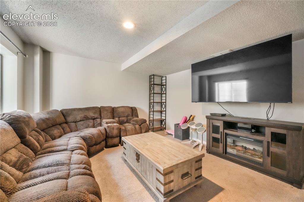Image 38 of 50: Basement family room with bar area