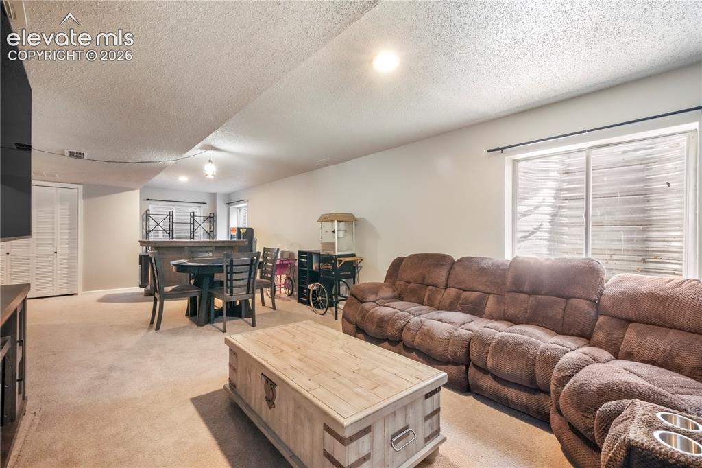 Image 39 of 50: Basement family room with bar area