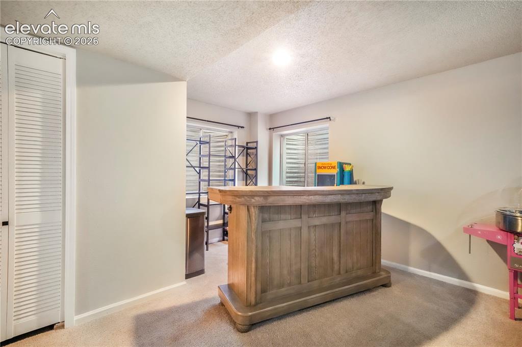 Image 40 of 50: Basement family room with bar area
