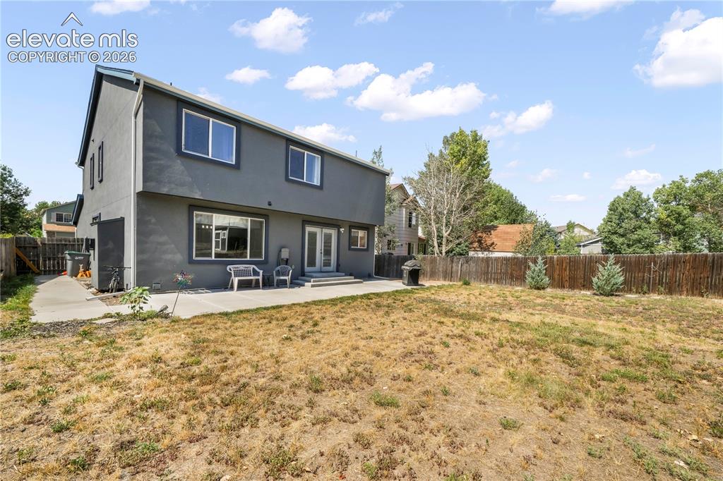 Image 44 of 50: Back of home with large backyard patio, multiple levels, basketball goal an
