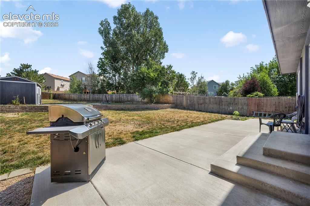 Image 46 of 50: Back of home with large backyard patio, multiple levels, basketball goal an