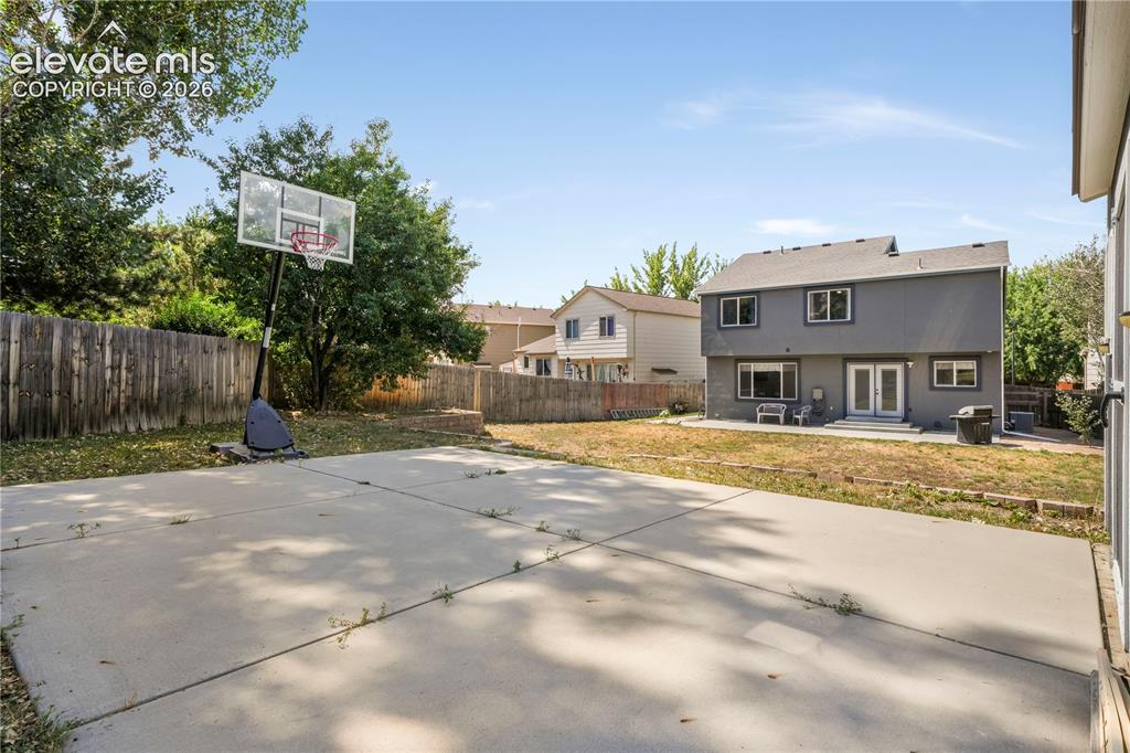 Image 48 of 50: Back of home with large backyard patio, multiple levels, basketball goal an