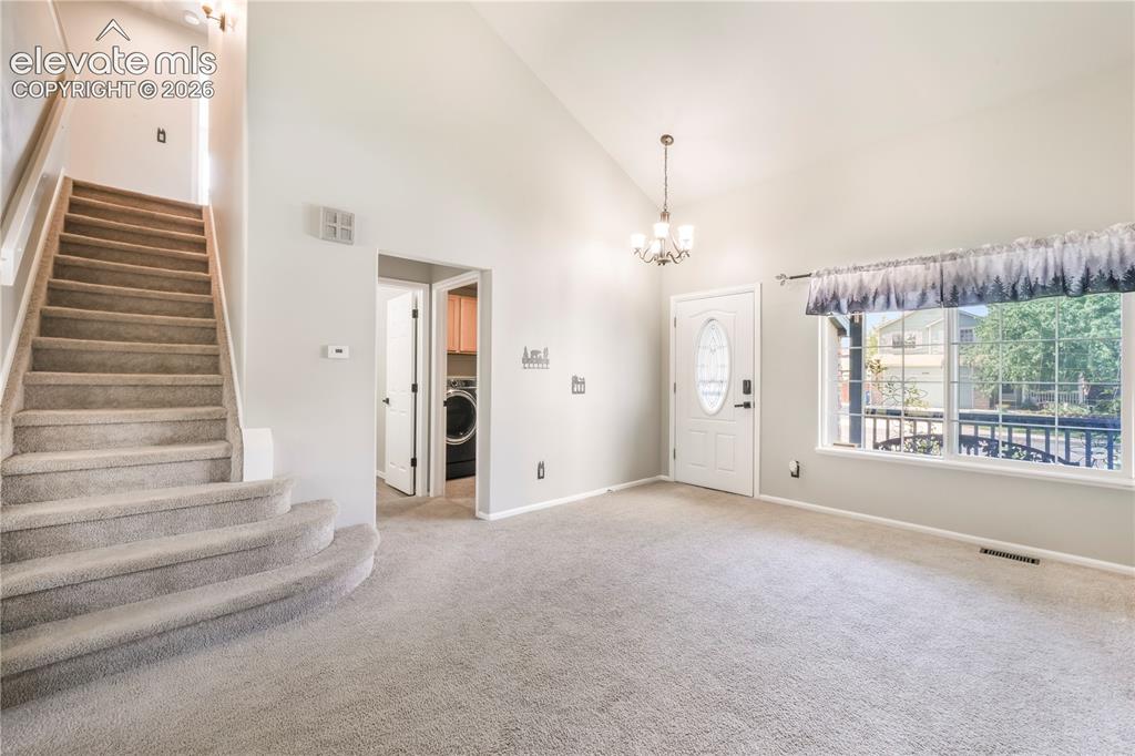 Image 6 of 50: Entry, front formal living room and views of laundry room with access to ga