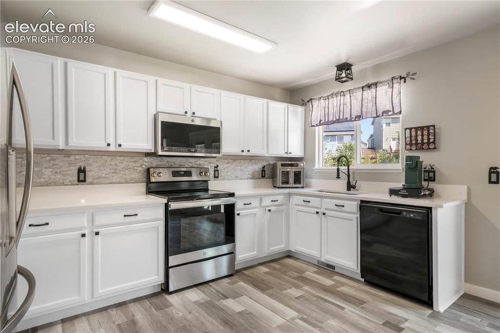 Image 9 of 50: Kitchen with new LVP floors, stainless steel appliances and abundant cabine