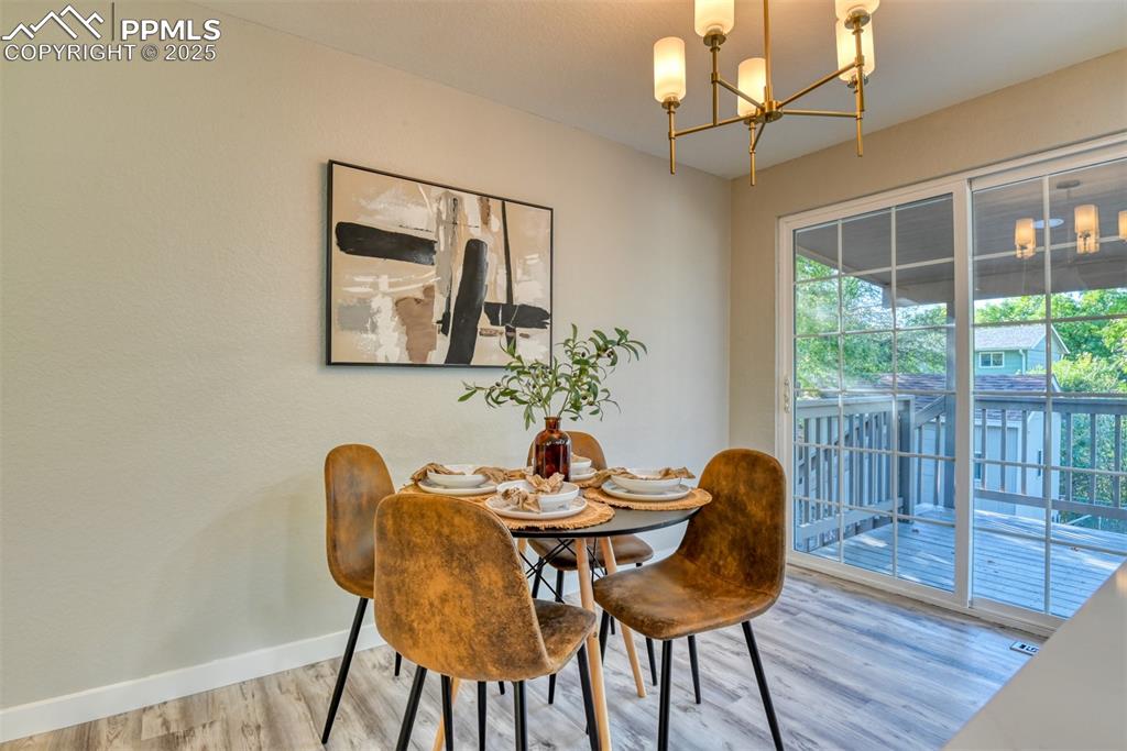 Image 14 of 48: Dining area featuring a chandelier and wood finished floors