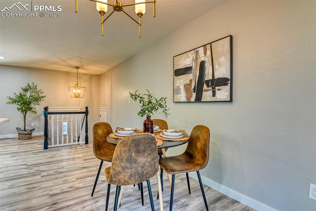 Image 16 of 48: Dining area with a chandelier and light wood finished floors