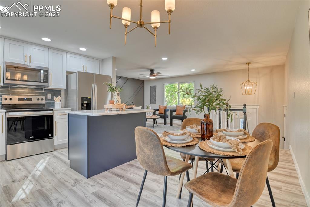 Image 17 of 48: Dining area with a chandelier, a ceiling fan, light wood-style floors, and 