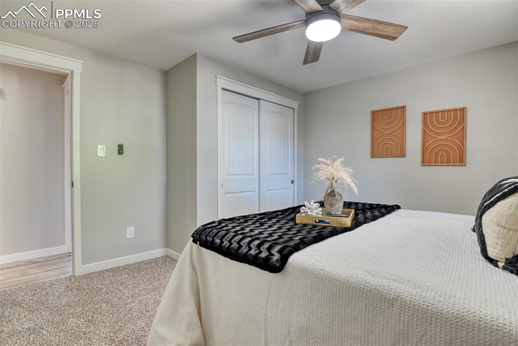 Image 19 of 48: Bedroom featuring light carpet, a closet, and a ceiling fan