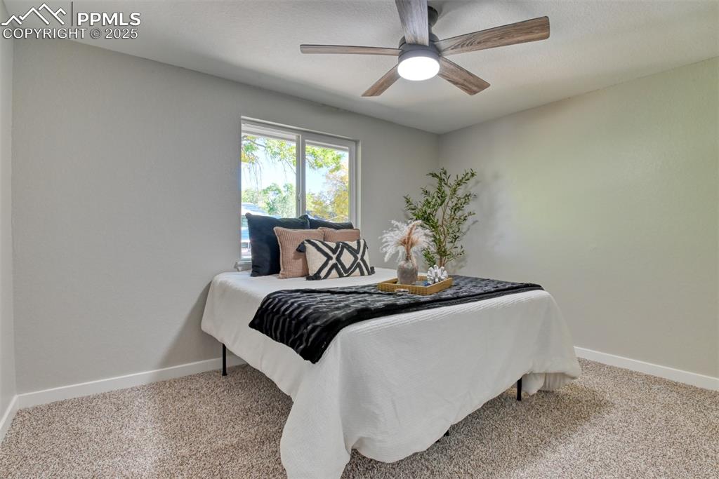 Image 20 of 48: Bedroom with carpet flooring and a ceiling fan