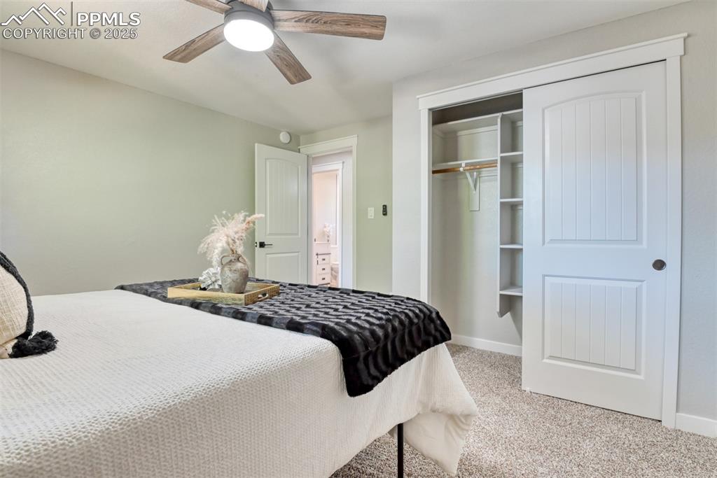 Image 21 of 48: Bedroom with light carpet, ceiling fan, and a closet