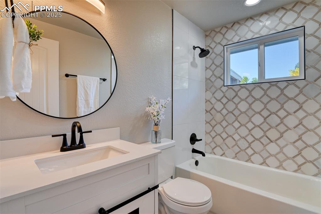 Image 22 of 48: Full bath featuring a textured wall, bathing tub / shower combination, and 