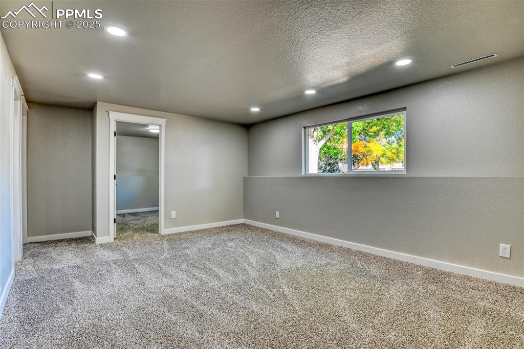 Image 26 of 48: Unfurnished room featuring carpet flooring, recessed lighting, and a textur