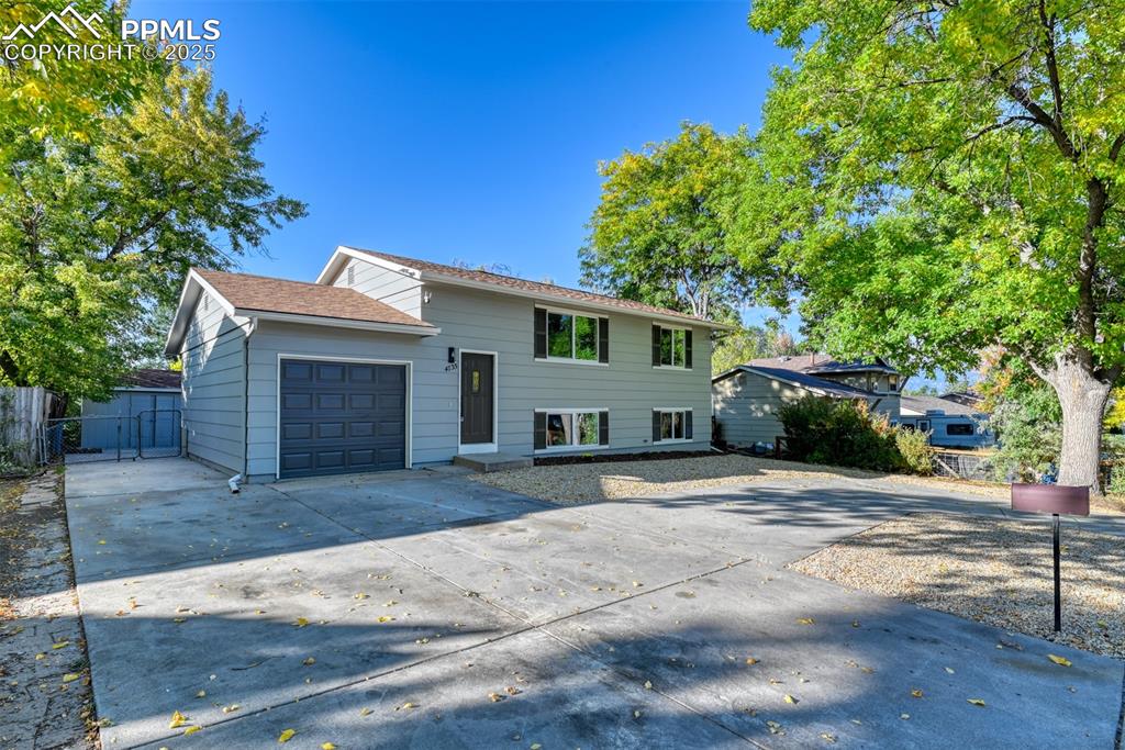 Image 3 of 48: Tri-level home with driveway and an attached garage