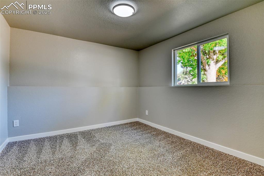 Image 34 of 48: Unfurnished room featuring carpet floors and a textured ceiling
