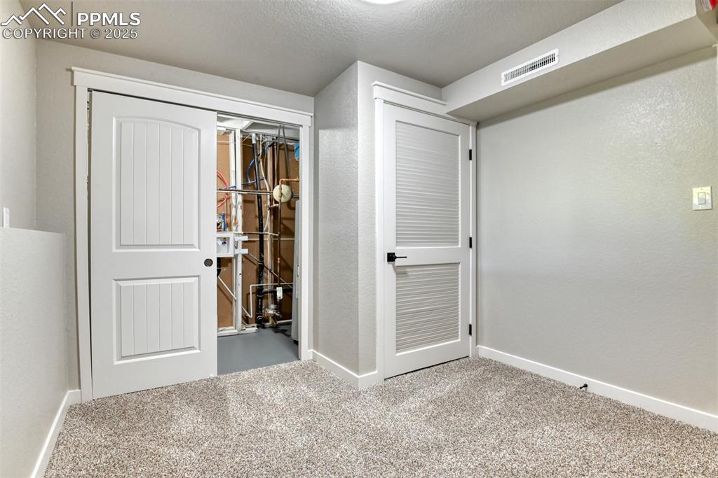 Image 39 of 48: Unfurnished bedroom with light colored carpet, a closet, and a textured cei