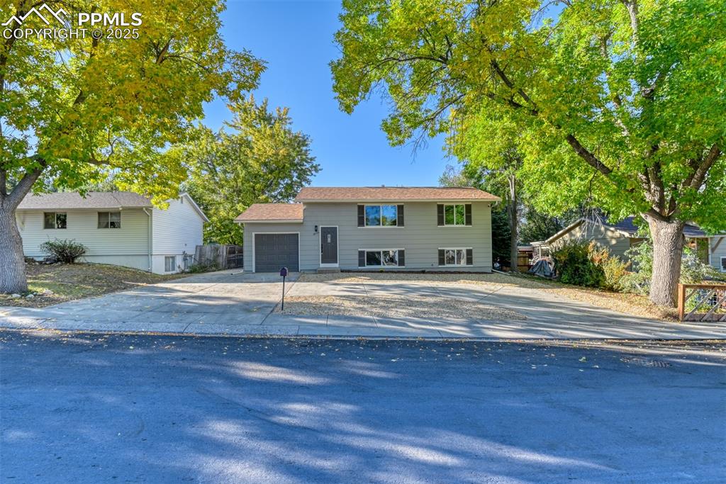 Image 4 of 48: Bi-level home featuring concrete driveway and a garage