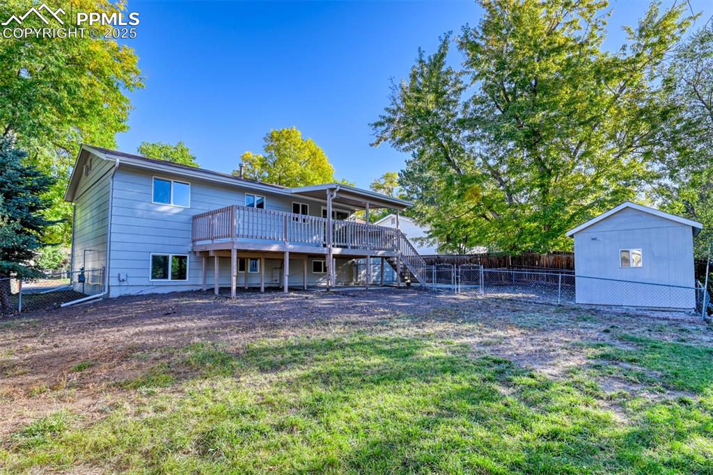 Image 44 of 48: Rear view of property featuring a fenced backyard, stairs, a wooden deck, a
