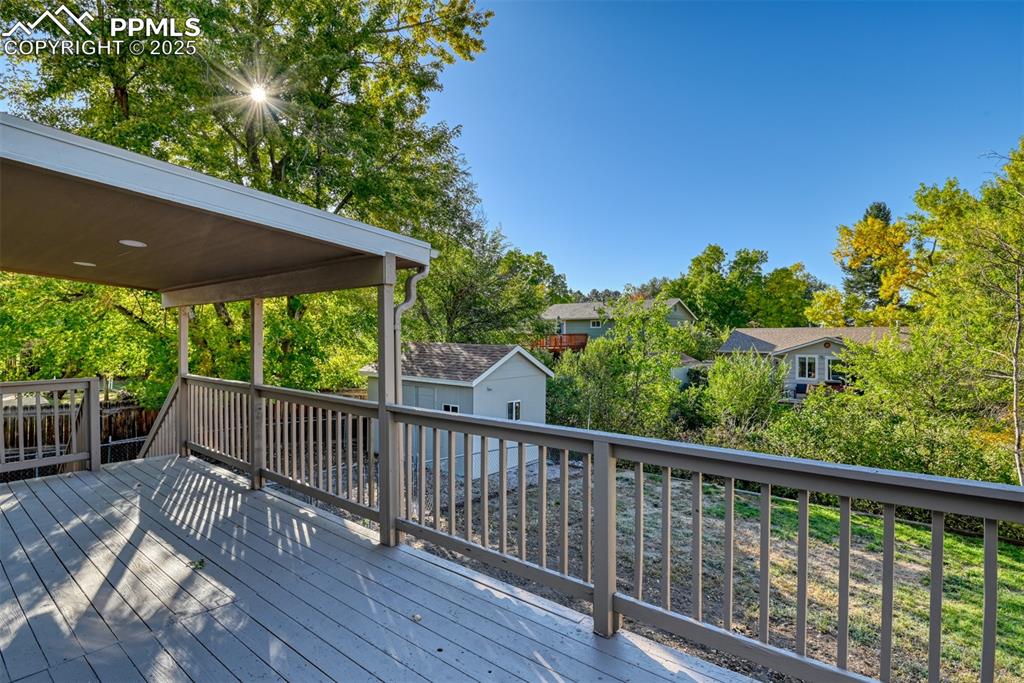 Image 46 of 48: Wooden terrace with view of scattered trees and an outdoor structure