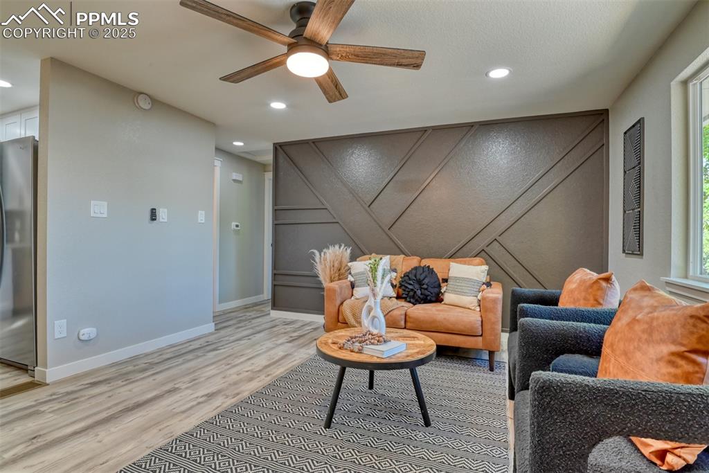 Image 6 of 48: Sitting room featuring a decorative wall, a ceiling fan, light wood-type fl