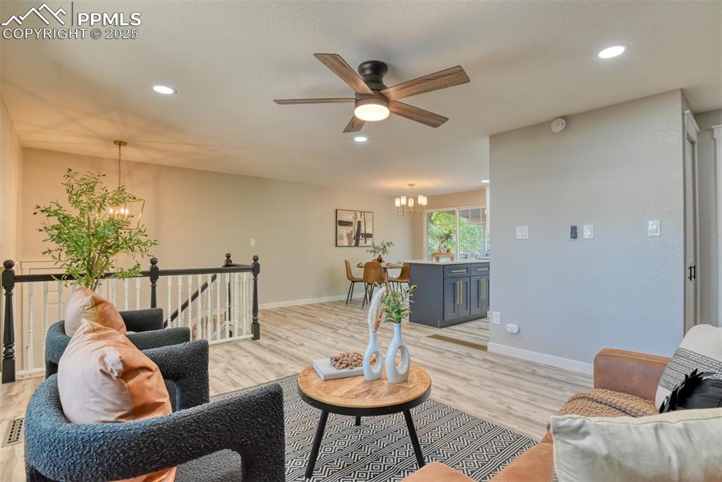 Image 7 of 48: Living area with a chandelier, recessed lighting, light wood-style flooring