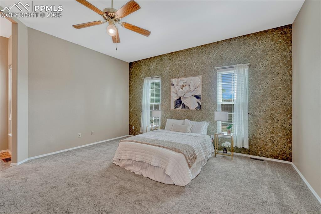 Image 26 of 47: Primary Bedroom with lighted ceiling fan