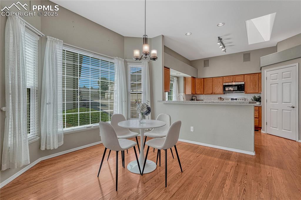 Image 3 of 47: Dining area with hardwood flooring and large windows