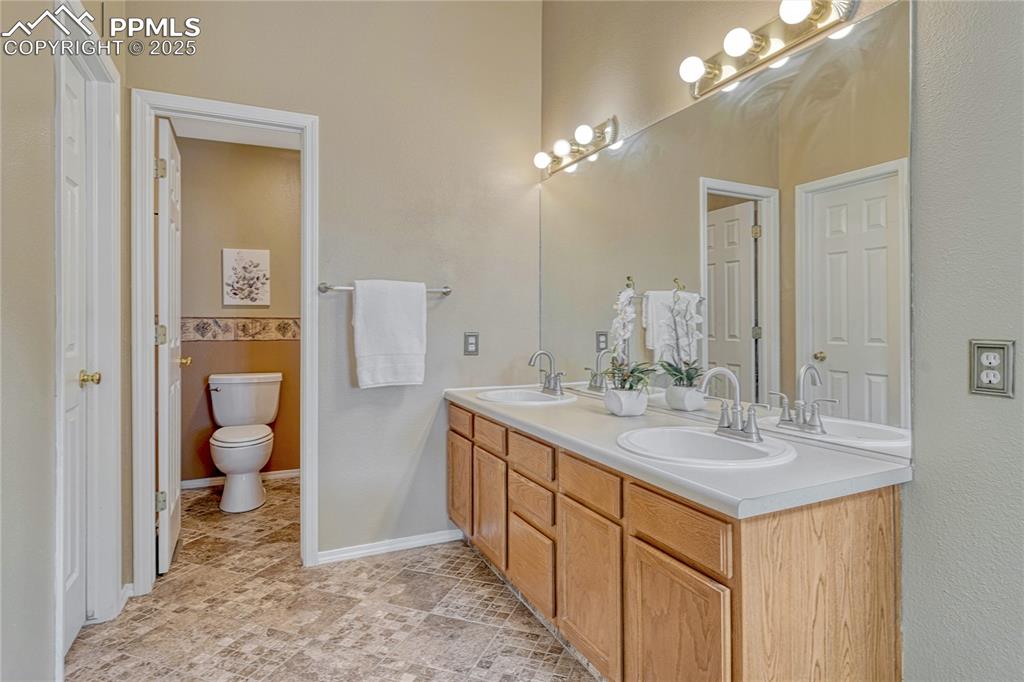 Image 6 of 47: Primary bath with double sink vanity and tile flooring