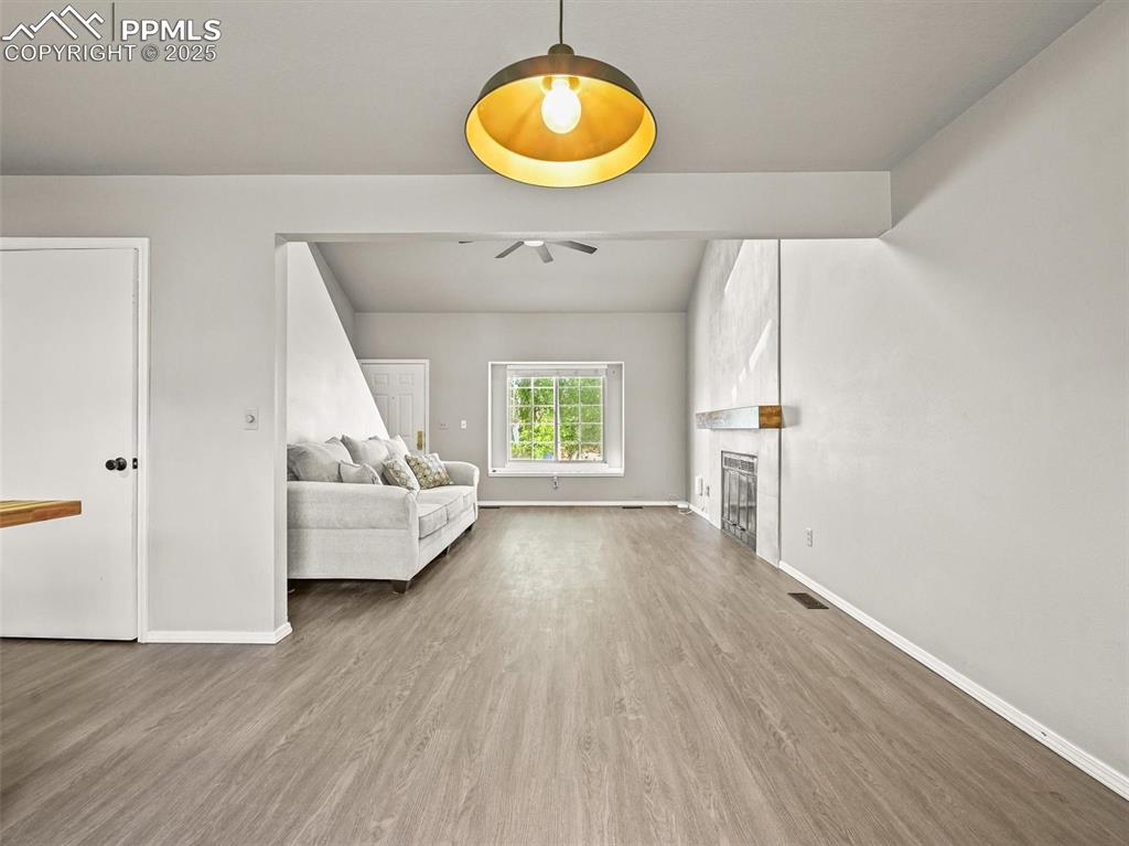 Image 11 of 47: Living room featuring a ceiling fan, baseboards, wood finished floors, and
