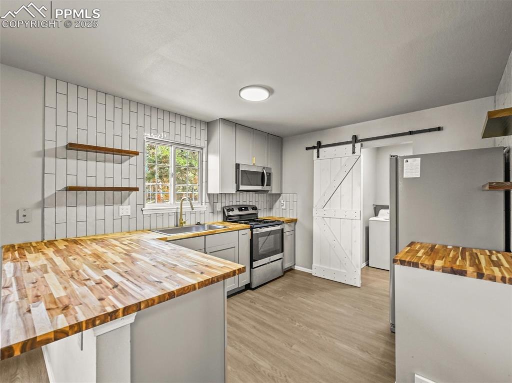 Image 17 of 47: Kitchen featuring butcher block countertops, appliances with stainless stee