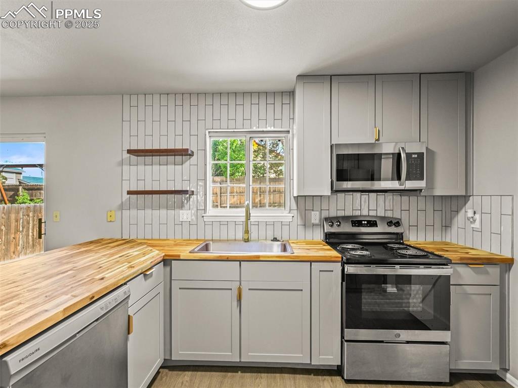 Image 20 of 47: Kitchen featuring butcher block countertops, appliances with stainless stee