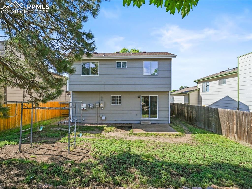 Image 23 of 47: Back of property with a fenced backyard and a patio
