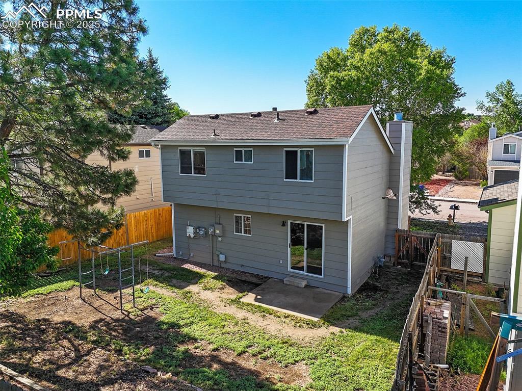 Image 27 of 47: Rear view of house with a patio, a fenced backyard, a chimney, and a shingl