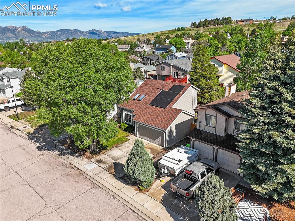 Image 3 of 47: Aerial view of residential area featuring a mountainous background
