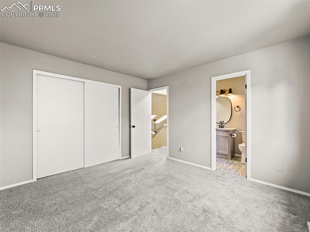 Image 30 of 47: Unfurnished bedroom featuring carpet flooring, a closet, ensuite bathroom,