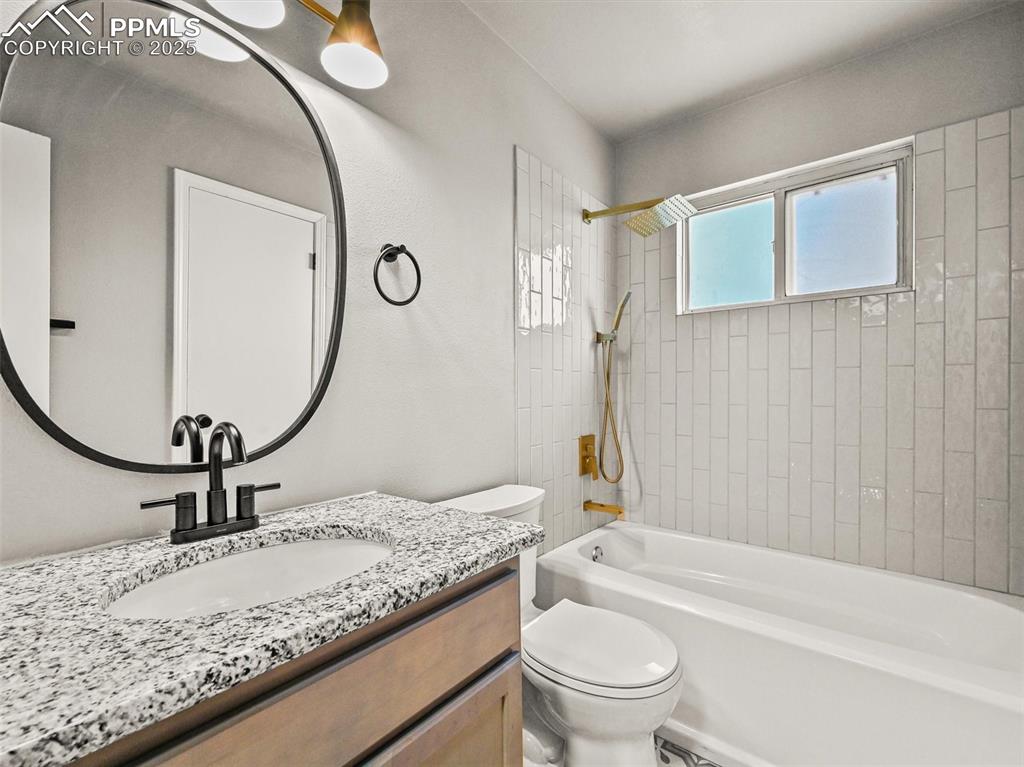 Image 32 of 47: Bathroom featuring toilet, bathtub / shower combination, and vanity