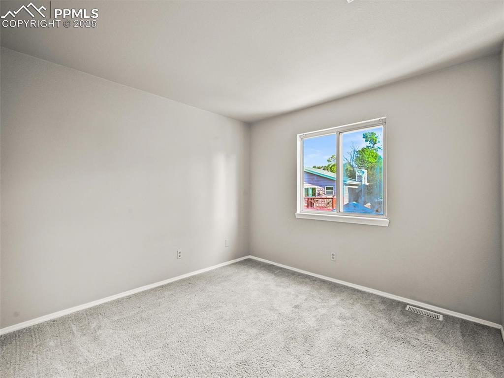Image 34 of 47: Spare room featuring carpet and baseboards