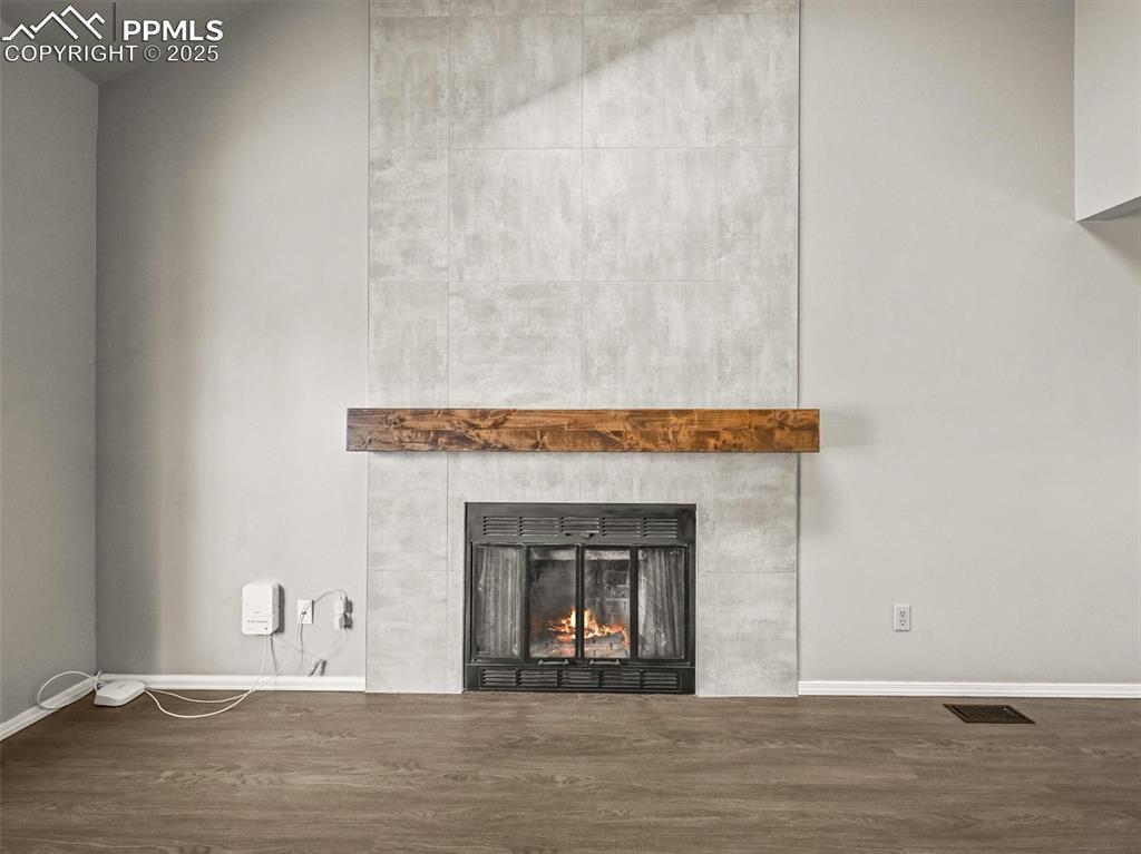 Image 8 of 47: Detailed view of wood finished floors, a fireplace, and baseboards