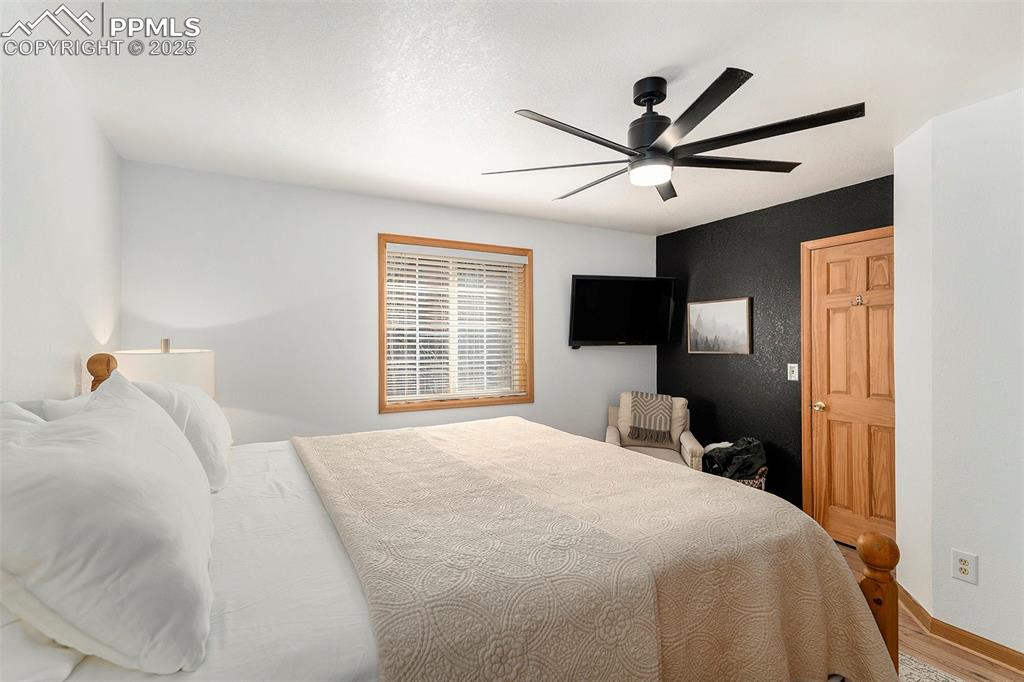 Image 14 of 25: Bedroom featuring ceiling fan and wood finished floors